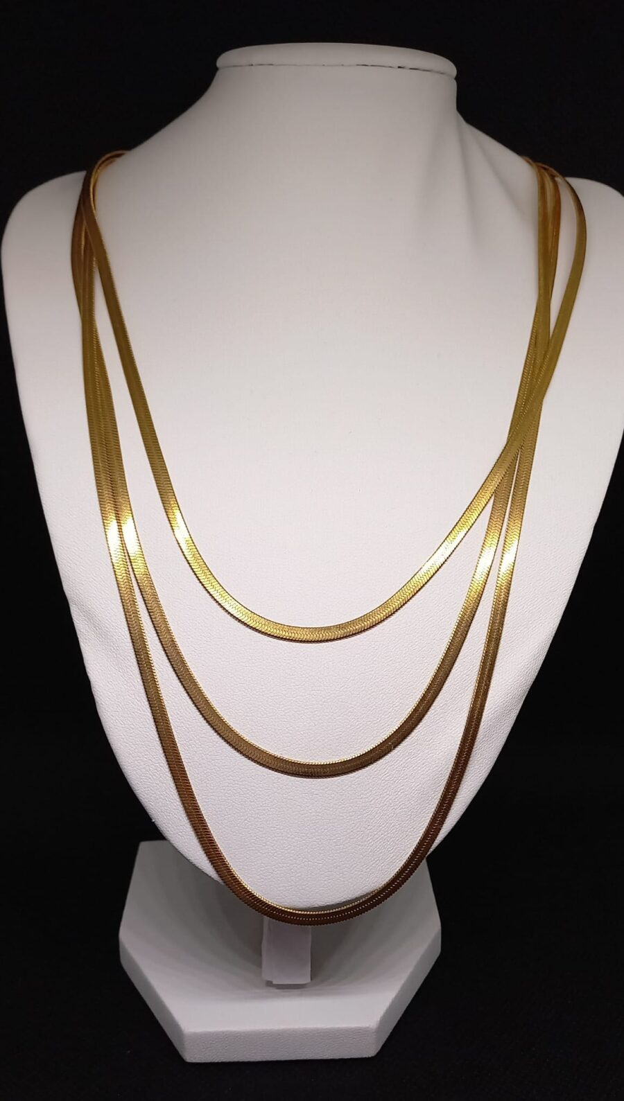Colar triplo de malha achatada dourado.